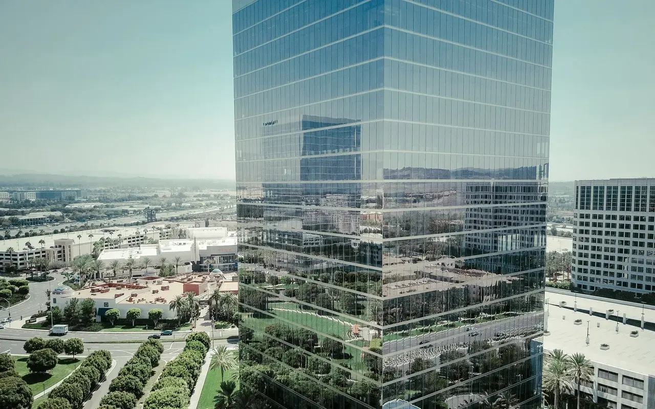 Une tour de bureaux en verre au-dessus d'un quartier d'affaires.
